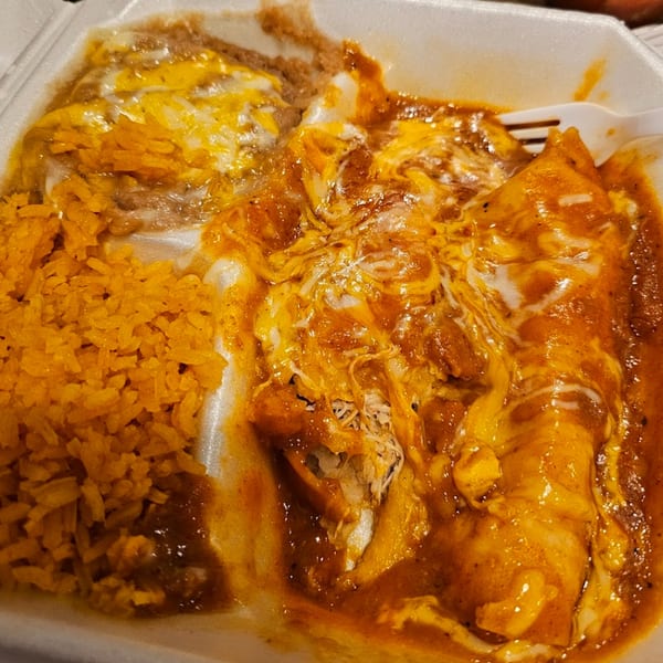 Sergio's Mexican Restaurant enchiladas with rice and beans, topped with melted cheese and red sauce.