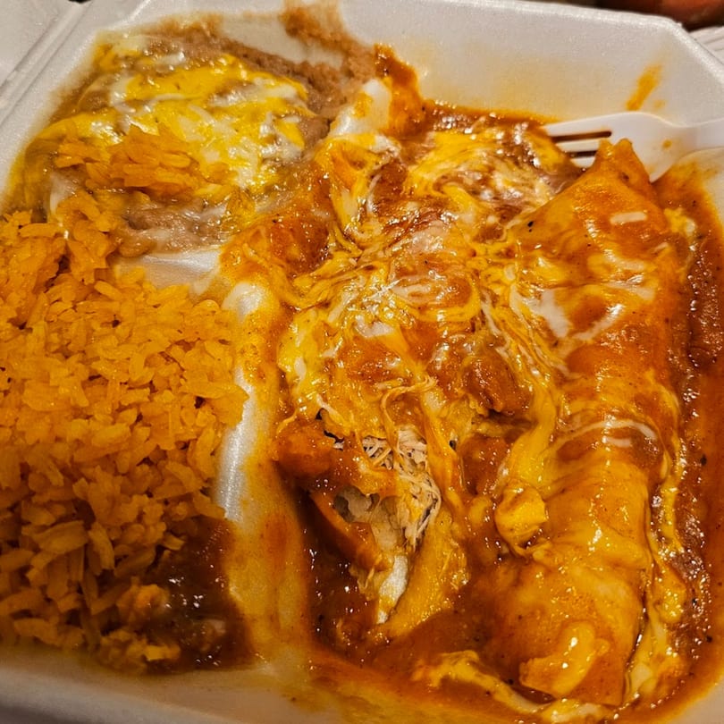 Sergio's Mexican Restaurant enchiladas with rice and beans, topped with melted cheese and red sauce.